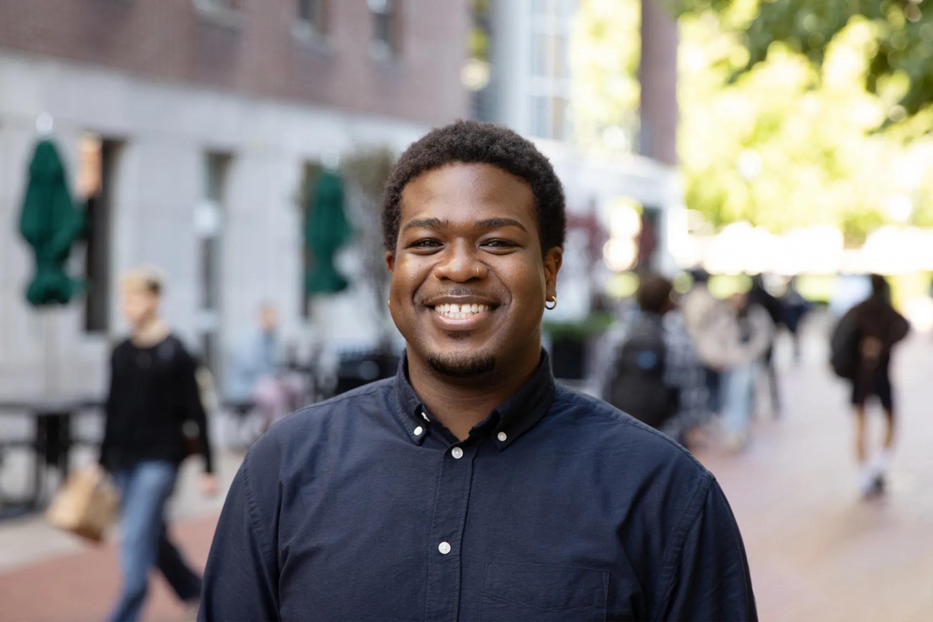 An individual wearing a blue shirt, posing for a portrait.